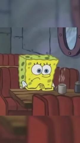 a spongebob sitting at a table with a cup of coffee