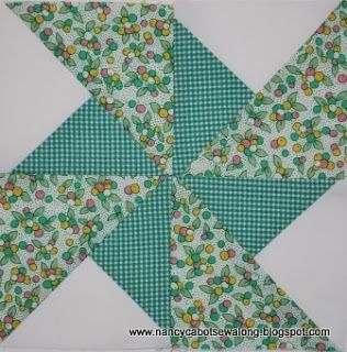 a green and white patchwork quilt with flowers on the center, as if it were made out of fabric