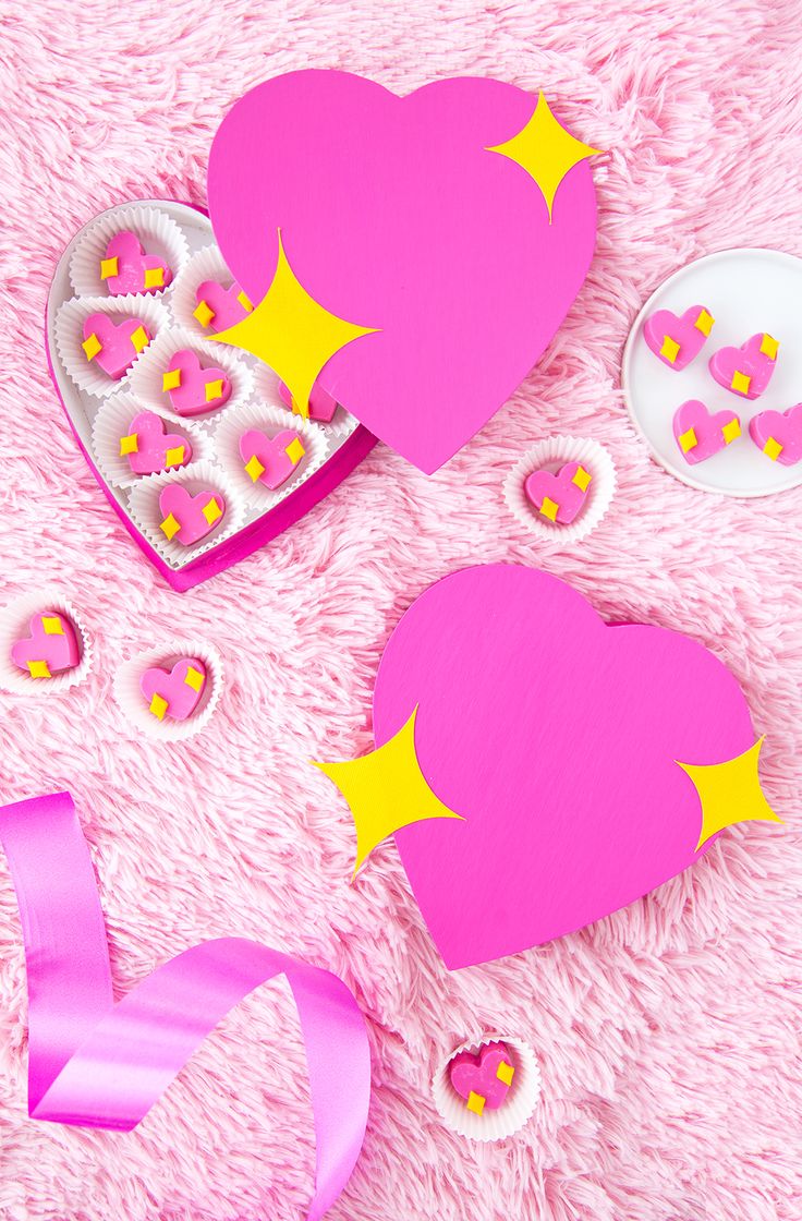 pink and yellow heart shaped paper cutouts with stars on them, next to a ribbon