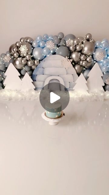 a white table topped with lots of silver and blue christmas decorations on top of it