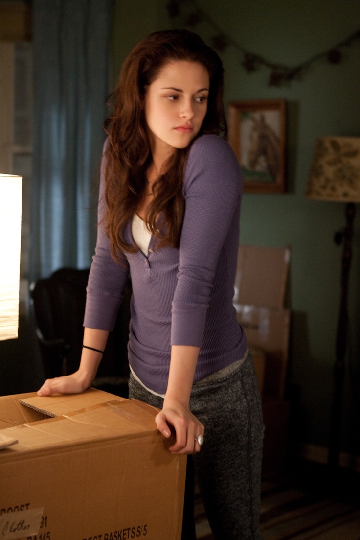 a woman standing next to a cardboard box