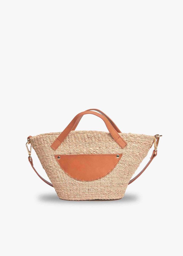 Sturdy straw and vegetable tanned leather come together to make the perfect warm weather tote. This compact version will take you from poolside to the city in a snap. Handcrafted from all-natural straw. Features hidden magnetic snap with an optional crossbody strap. Measures 13” W x 6.5” H x 4” D with a 2” handle drop. Chic Natural Beach Bag With Handles, Trendy Natural Color Crossbody Beach Bag, Chic Natural Straw Bag With Leather Handles, Crossbody Beach Bag With Braided Handles, Chic Crossbody Straw Bag With Leather Handles, Everyday Straw Bag With Top Handle And Adjustable Strap, Beach Bucket Bag With Woven Leather And Double Handle, Chic Beach Bag With Top Handle In Natural Fiber, Beach Bucket Bag With Double Handle In Woven Leather