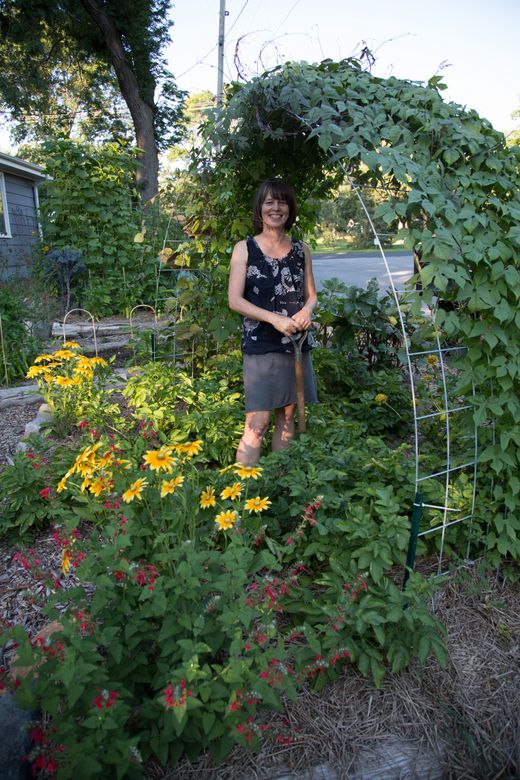 a woman standing in the middle of a garden