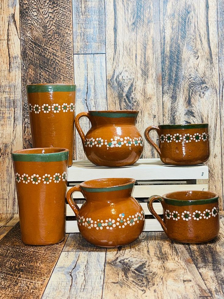 a stack of brown and green pottery on top of a wooden table