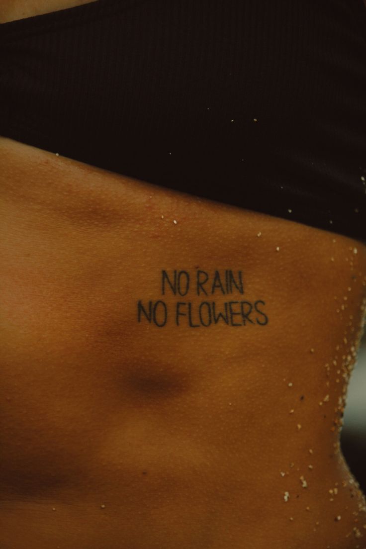 a woman's stomach with the words no rain, no flowers written on it