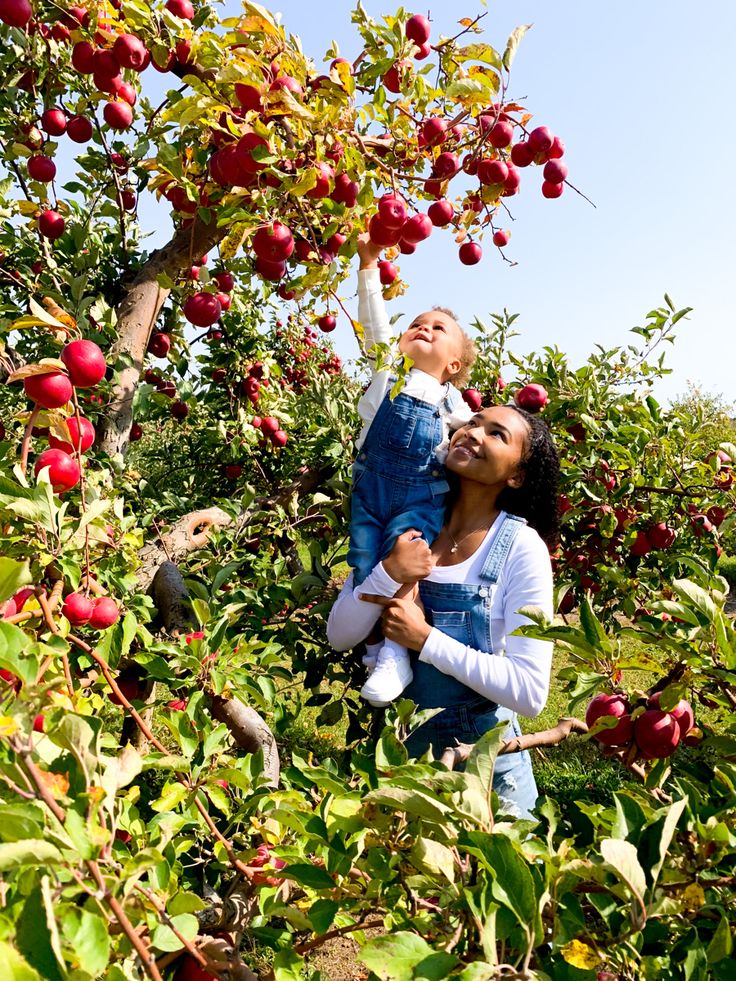 Kiara (mom) and Legend (son) wearing matching overalls standing in front of apple trees Legend sitting on moms shoulder reaching up picking apples Family Apple Picking Outfits, Apple Picking Family Photos, Apple Arch, Apple Orchard Photoshoot Family, Apple Picking Pictures, Orchard Photoshoot, Apple Picking Photos, Fall Family Outfits, Apple Picking Outfit