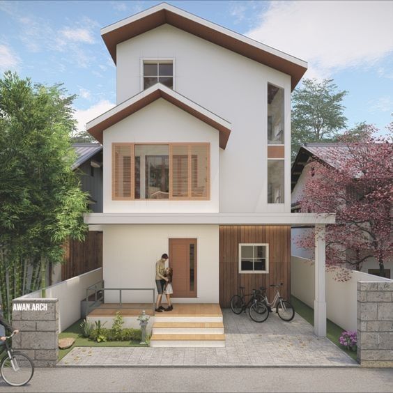 a person standing in front of a house with bicycles parked on the side of it