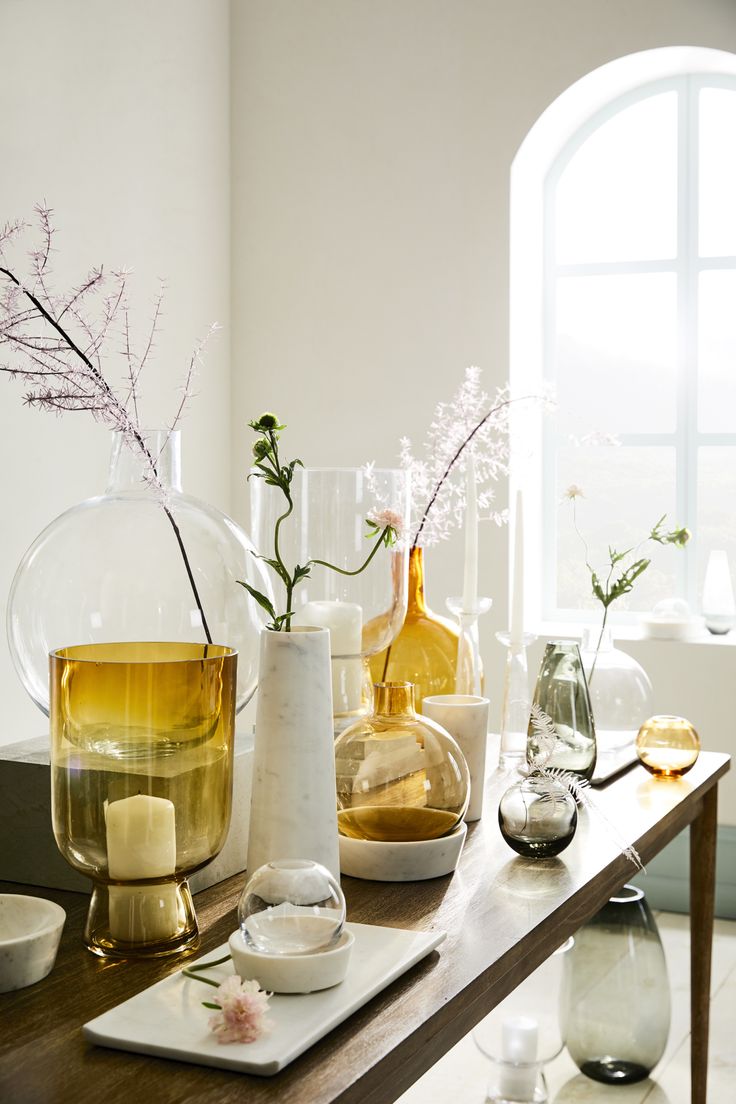 vases with flowers and candles on a table