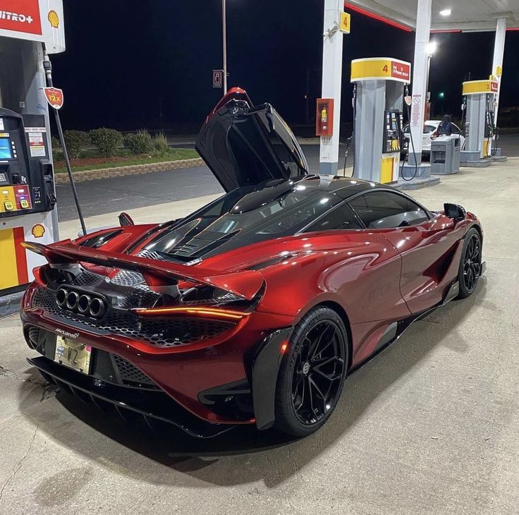 a red sports car parked at a gas station