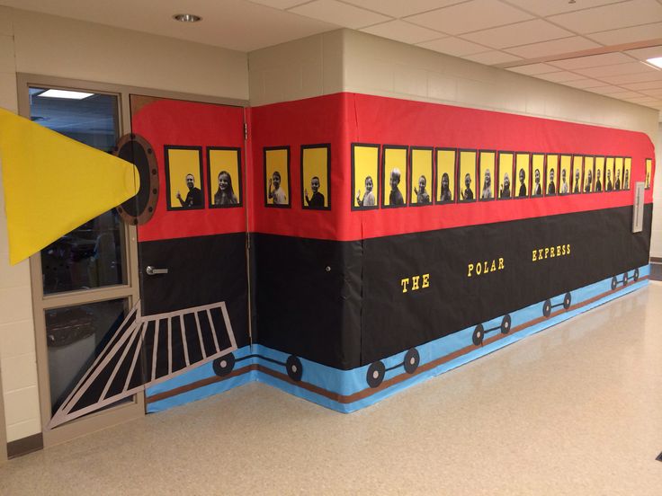 a red and black train is on display in the school hallway, with yellow doors