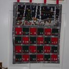 a christmas calendar hanging on the wall in a bathroom with red and green decorations around it