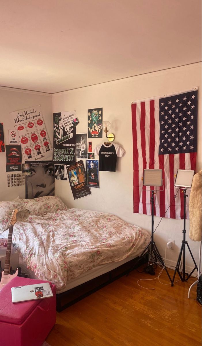 a bed room with a neatly made bed and american flags on the wall