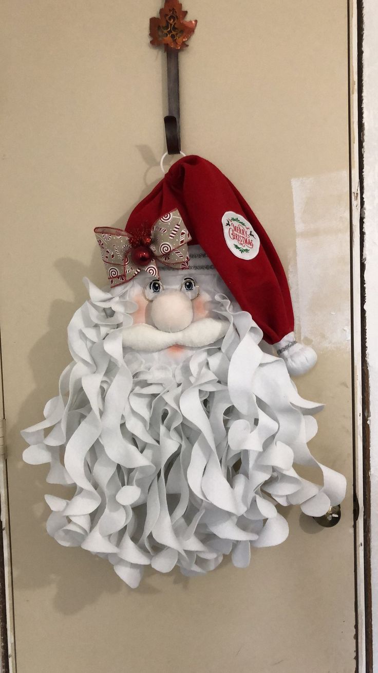 a door hanger with a red hat and white ruffle skirt on it's head