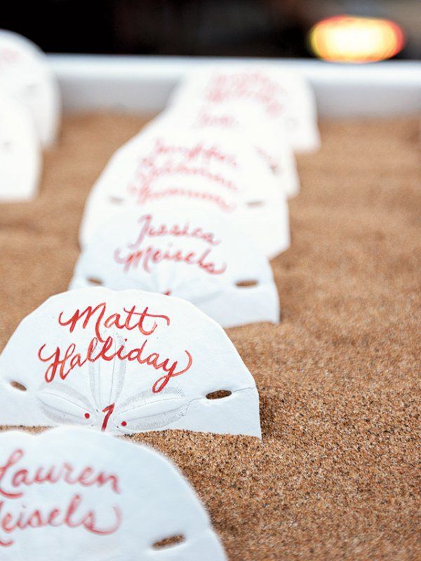 white masks with red writing on them sitting in a tray filled with sand and gravel