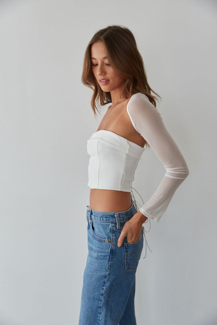 So trendy in the Rio Corset Shrug Set! This corset top is complete with a strapless fold over neckline, a lace up back with silver grommets, and a mesh long sleeve shrug. Available in black and white. Pair with your favorite jeans to complete the look! Details Top self: 95% Nylon, 5% Spandex Top lining 92% Polyester, 8% Spandex Shrug self: 90%, Nylon, 10% Spandex Shrug lining: 92% Polyester, 8% Spandex Item sold as set Silicon grips Boning Material has some stretch Machine wash cold / Tumble dry White Stretch Top With Boned Bodice, White Stretch Tops With Boned Bodice, Spring Stretch Crop Top With Corset Back, Spring Tops With Corset Back And Stretch, Spring Stretch Tops With Corset Back, Spring Tops With Stretch Boned Bodice, Spring Stretch Tops With Boned Bodice, Spring Tops With Stretch And Boned Bodice, White Boned Bodice Top For Evening