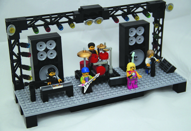 a lego stage set with people playing music on the stage and two microphones in front of it