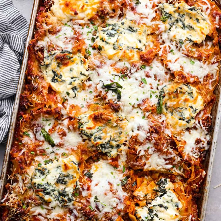 a casserole dish with cheese and spinach