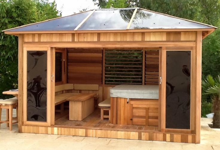 an outdoor sauna with two benches and a hot tub