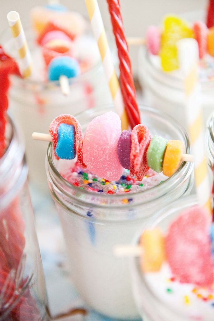 a jar filled with candy and marshmallows on top of a white table