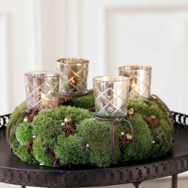 a tray topped with candles and moss covered glasses on top of a table next to other items