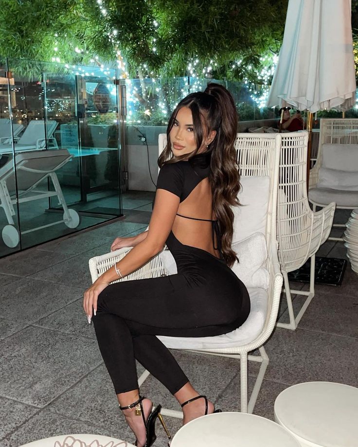 a woman sitting on top of a white chair