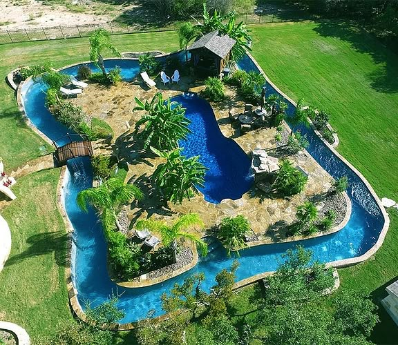 an aerial view of a pool surrounded by palm trees