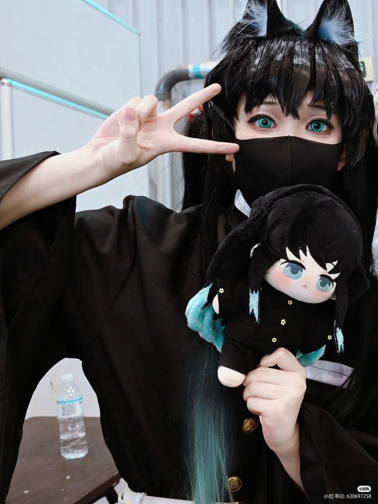 a woman with black hair and blue eyes holding a stuffed animal in front of her face