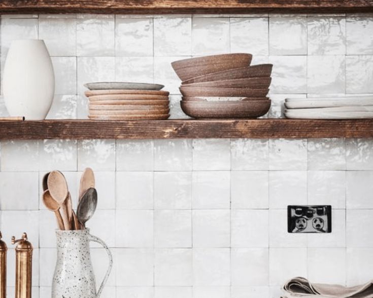 wooden utensils are sitting on the shelves in this kitchen