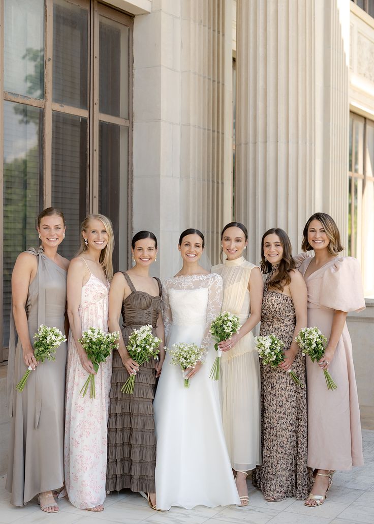 Bridesmaids standing with bride on wedding day wearing mismatched neutral dresses Winter Wedding Mix And Match Bridesmaids, Gold Mix And Match Bridesmaid Dresses, Earthy Neutral Bridesmaid Dresses, Different Champagne Bridesmaid Dresses, Taupe Bridesmaid Dresses Mismatched, Cream Bridesmaid Dresses Mismatched, Wedding Party Neutral Colors, Neutral Tone Bridesmaid Dresses, Dark Neutral Bridesmaid Dresses