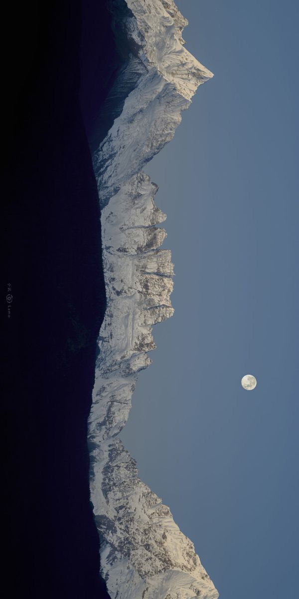 the moon is seen over an icy mountain range in this view from earth's surface