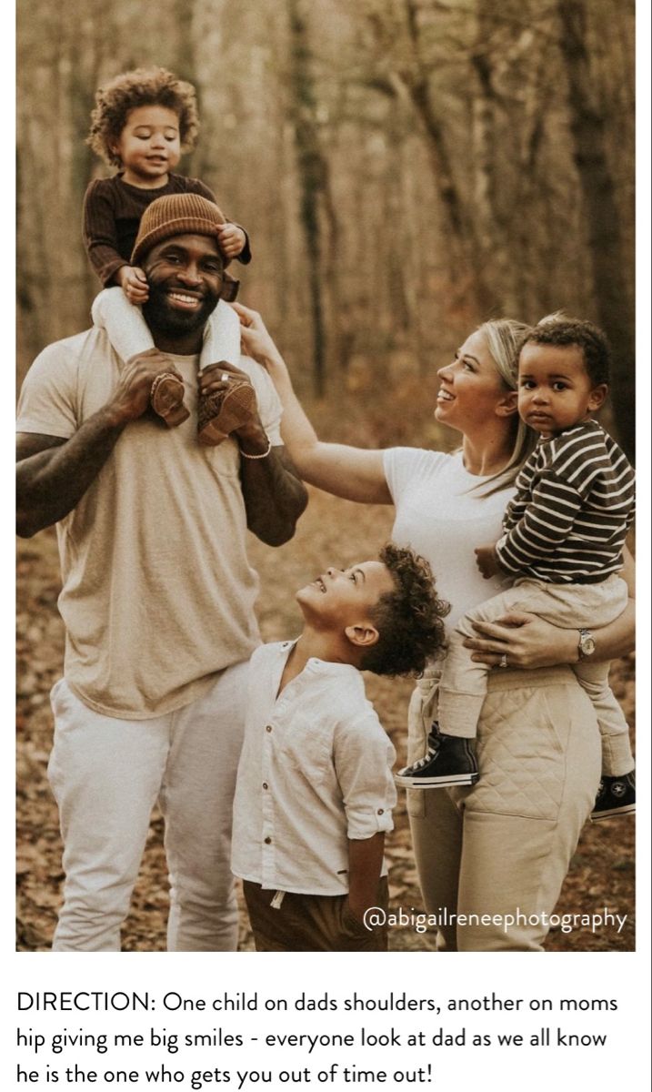 a group of people standing around each other in the woods with one holding a baby