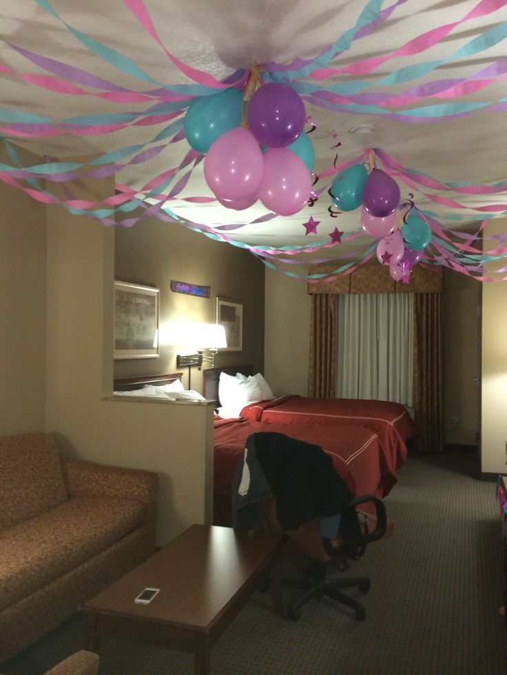 a room with balloons and streamers hanging from the ceiling