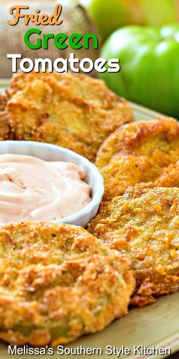 fried green tomatoes with dip in a bowl on a plate next to an apple and peppers