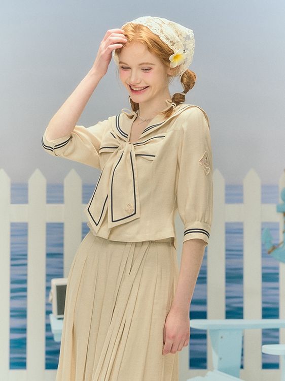 Elevate your Lolita wardrobe with our charming top featuring a classic sailor collar and a big bow embellishment on the chest. The sleeves are adorned with matching tonal embroidery, adding a delightful touch to this must-have piece.  Please note that this product includes only the top.  Garment Size   	 		 			Size 			S 			M 			L 			XL 		 		 			Full Length 			46 			47 			48 			49 		 		 			Shoulders 			37 			38 			39 			40 		 		 			Bust 			86 			90 			94 			98 		 		 			Sleeve Length 			37 			38 Classic Spring Tops With Bow Detail, Classic Bow Tops For Spring, Fitted Tops With Sailor Collar For Spring, Spring Bow Collar Blouse, White Collared Top With Bow, Collared Tops With Bow For Spring, Fitted Cotton Blouse With Bow, White Sailor Collar Top For Summer, Cream Peter Pan Collar Blouse For Summer