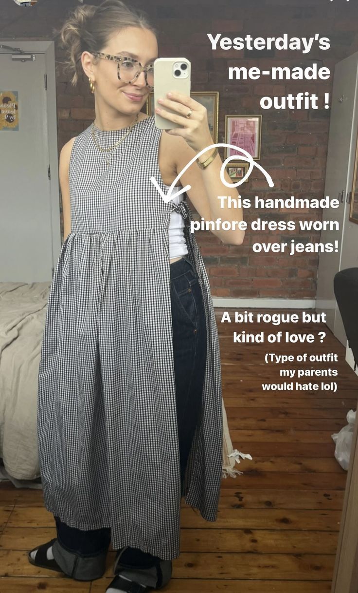 a woman taking a selfie with her cell phone while wearing an apron and jeans