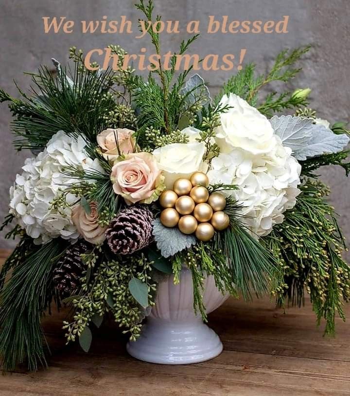 a white vase filled with flowers and greenery