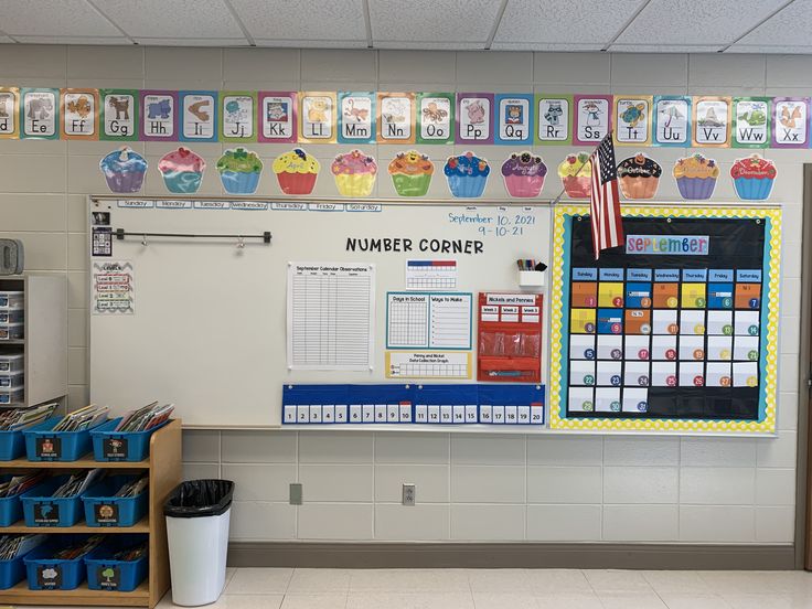 a classroom wall with cupcakes and calendars hanging on the wall in front of it