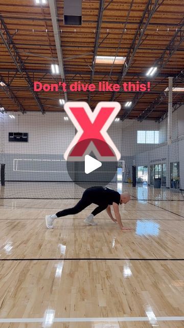 a woman is doing a handstand on the floor in an indoor volleyball court