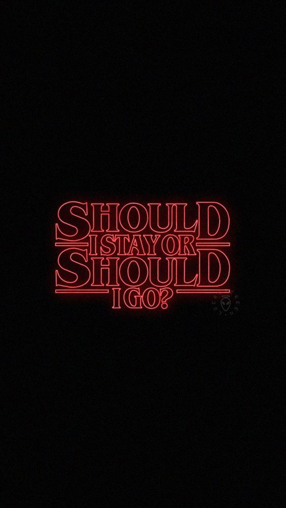 a red neon sign that says should you stay in the dark? or should it go?