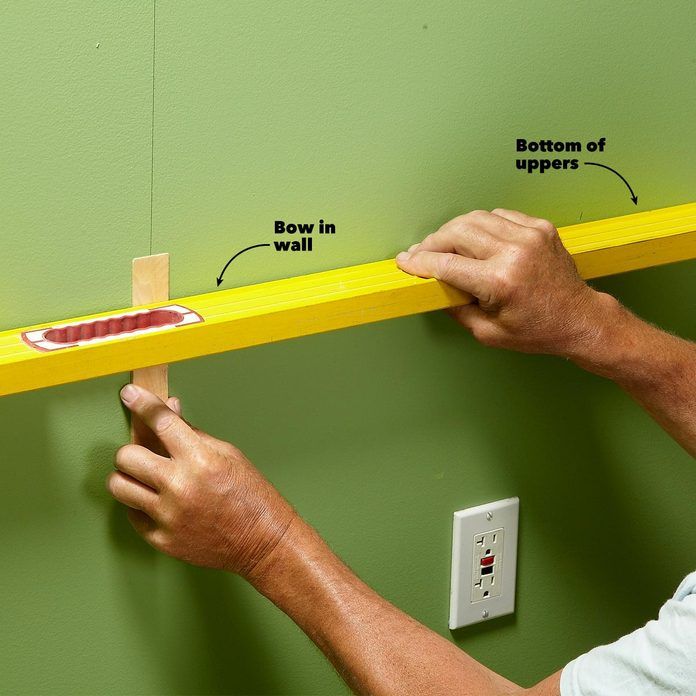 a man is measuring the width of a wall with a tape measure ruler on it