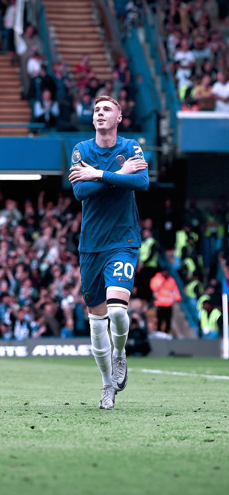 a soccer player with his arms crossed on the field in front of a large crowd