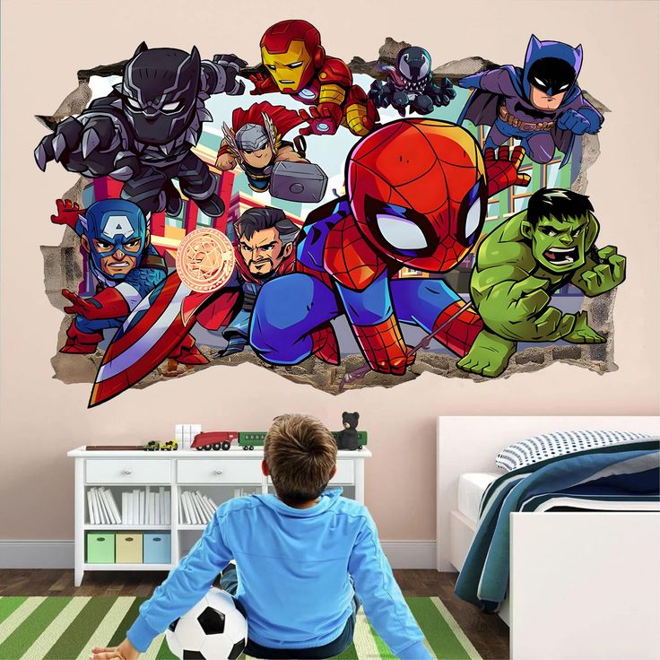 a boy is sitting on the floor in front of a wall mural with avengers characters