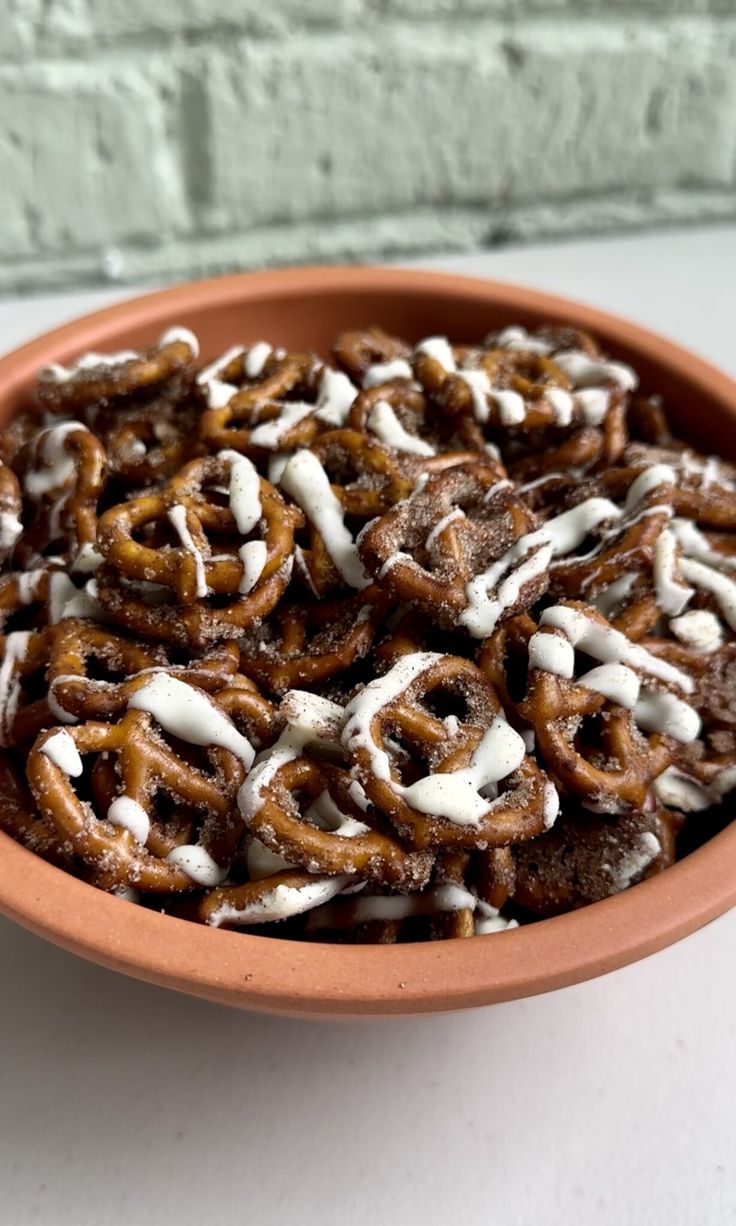 a bowl full of pretzels with icing on top