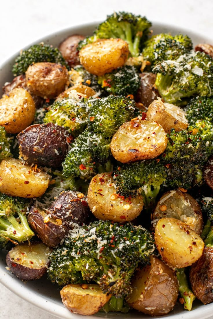 a white bowl filled with potatoes and broccoli