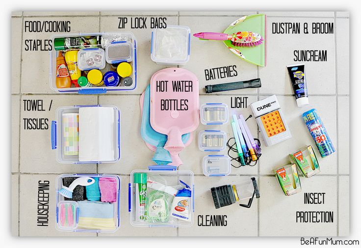 the contents of an organized travel kit laid out on a tiled floor, including toothbrushes and other items