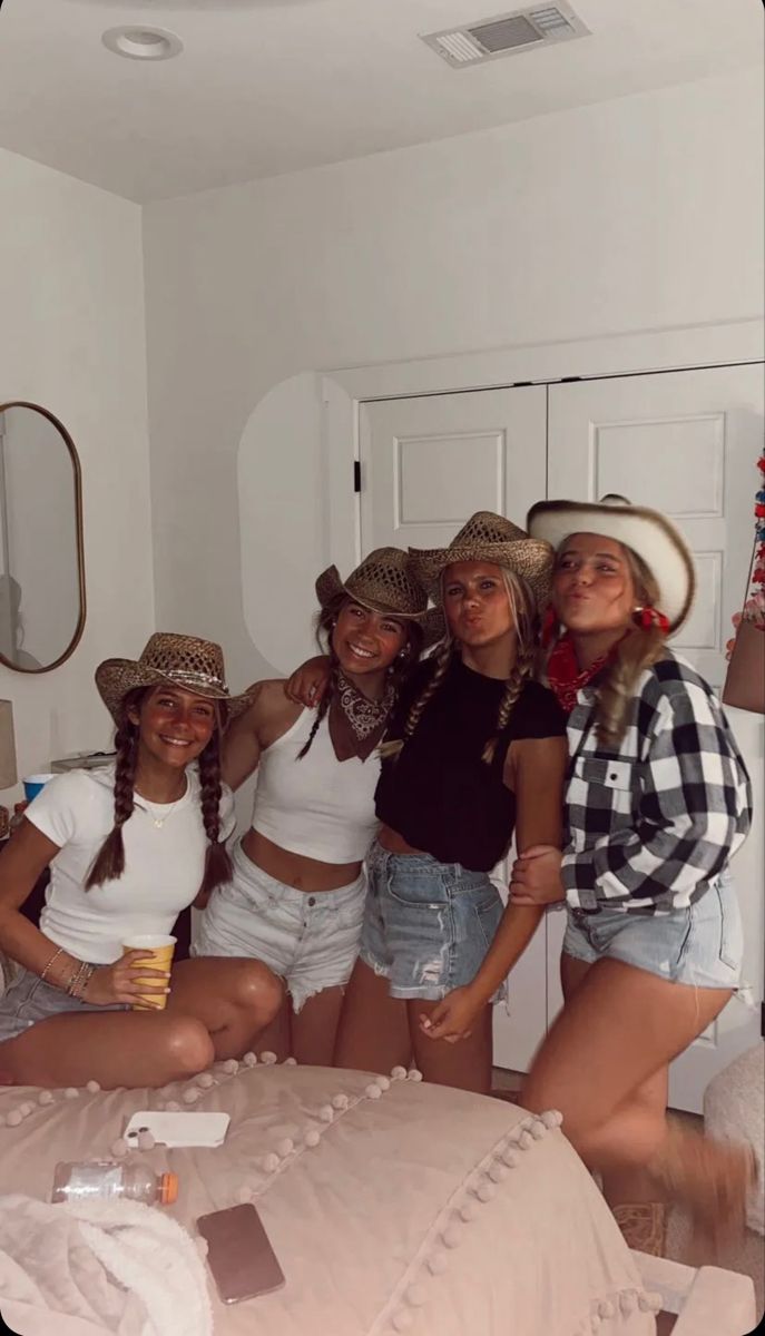 four girls in hats are posing for the camera