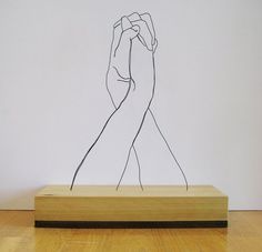 a wooden block with a drawing of two hands holding each other