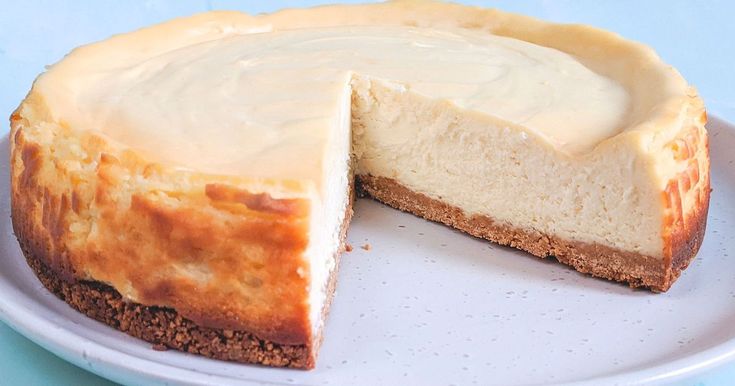 a cheesecake on a plate with one slice cut out