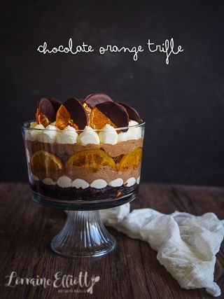 there is a dessert with orange slices in it on the table and an inscription that reads chocolate orange trifle