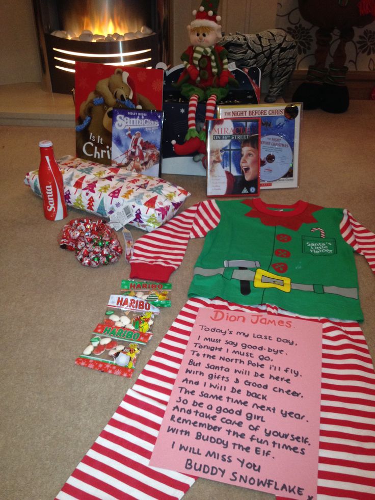 christmas gifts are laid out on the floor in front of a fire place with an elf's pajamas